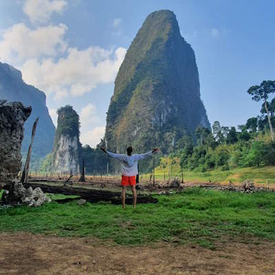 Person standing with open arms in Khao Sok.